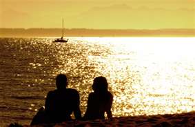 couple sitting on beach sunset 21